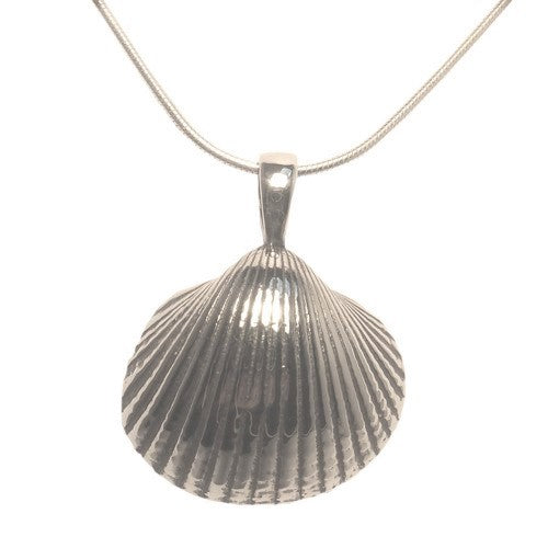 A Wildlife Pendant - Cockle Shell With Chain from Gallardo & Blaine Designs features a cockleshell pendant. The shell's surface has fine, textured lines, creating a realistic, ribbed appearance. The silver pendant hangs from a smooth, delicate chain.