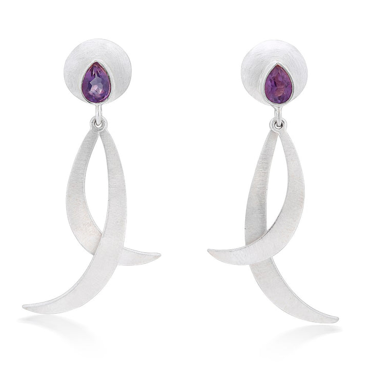 Introducing the Juno Earrings in various gemstones by Gallardo & Blaine Designs: a pair of elegant silver drop earrings featuring a unique curved design. Each earring has a circular top with a teardrop gemstone set in the center, from which two curved silver strands dangle. The design is both modern and sophisticated.