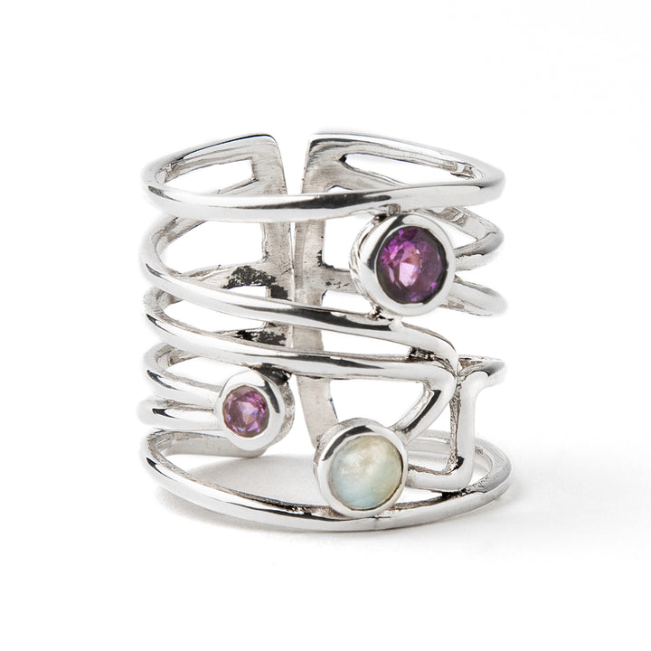 A Lattice Ring in various gemstones by Gallardo & Blaine Designs in silver featuring an open, multi-band design with three gemstones: a purple amethyst, a smaller purple stone, and a round opal, all set in a vertical arrangement. The ring's bands are intertwined, creating a contemporary design that is both modern and artistic.