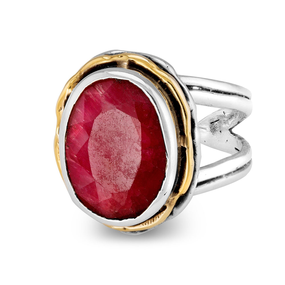 The Magnolia Ring in silver gold & various gemstones by Gallardo & Blaine Designs is a sterling silver piece featuring a large, faceted oval red gemstone prominently set in the center. Encircled by a gold-toned bezel on a split silver band, this statement ring blends elegance with a touch of vintage style.