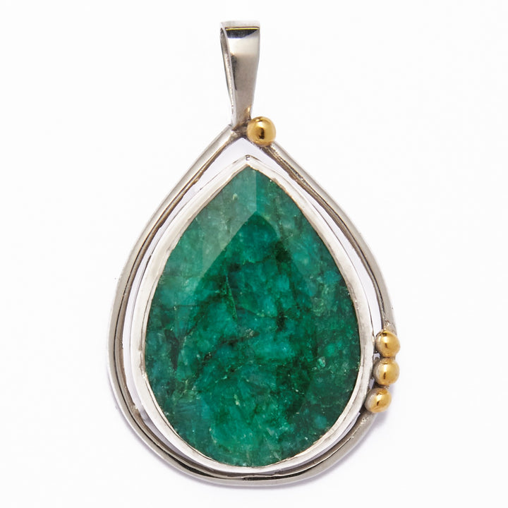 The Poppy Pendant Large in various gemstones by Gallardo & Blaine Designs features a teardrop-shaped design with a large, green labradorite stone at its center, encased in a sterling silver frame. Adorned with small gold accents on one side, it creates an elegant asymmetrical look. A simple silver bail completes this stunning piece.