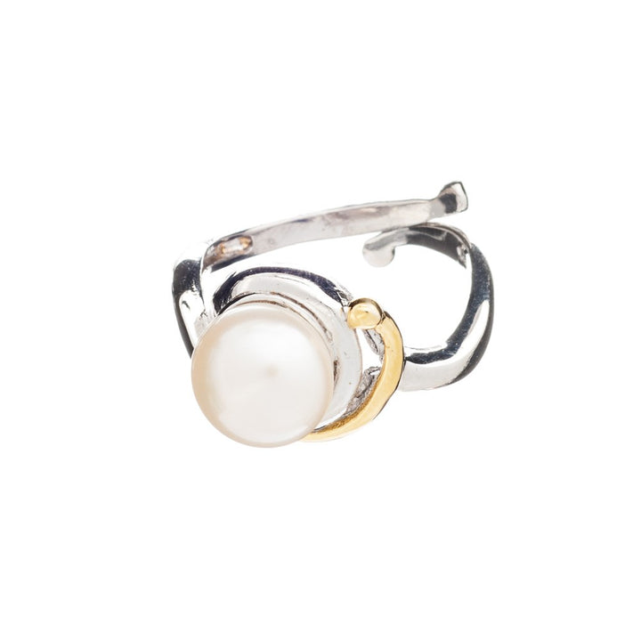 The Wave Ring by Gallardo & Blaine Designs is a silver open band ring featuring a large centrally set white pearl, with a thin gold accent forming a partial halo around the pearl. This adjustable silver ring has a modern, irregular design, combining elegant silver and gold elements perfectly.