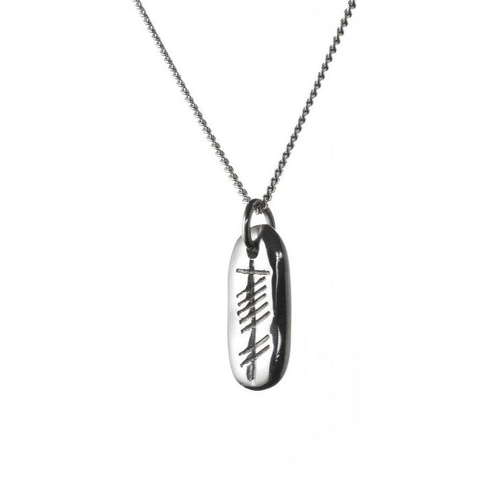 A close-up image of a sterling silver necklace with a rectangular Ogham Treasure Love (Grá) Carved Silver Pendant. The pendant features an engraved design resembling tally marks, with five vertical lines crossed by four diagonal lines. The pendant hangs from a fine silver chain against a white background.